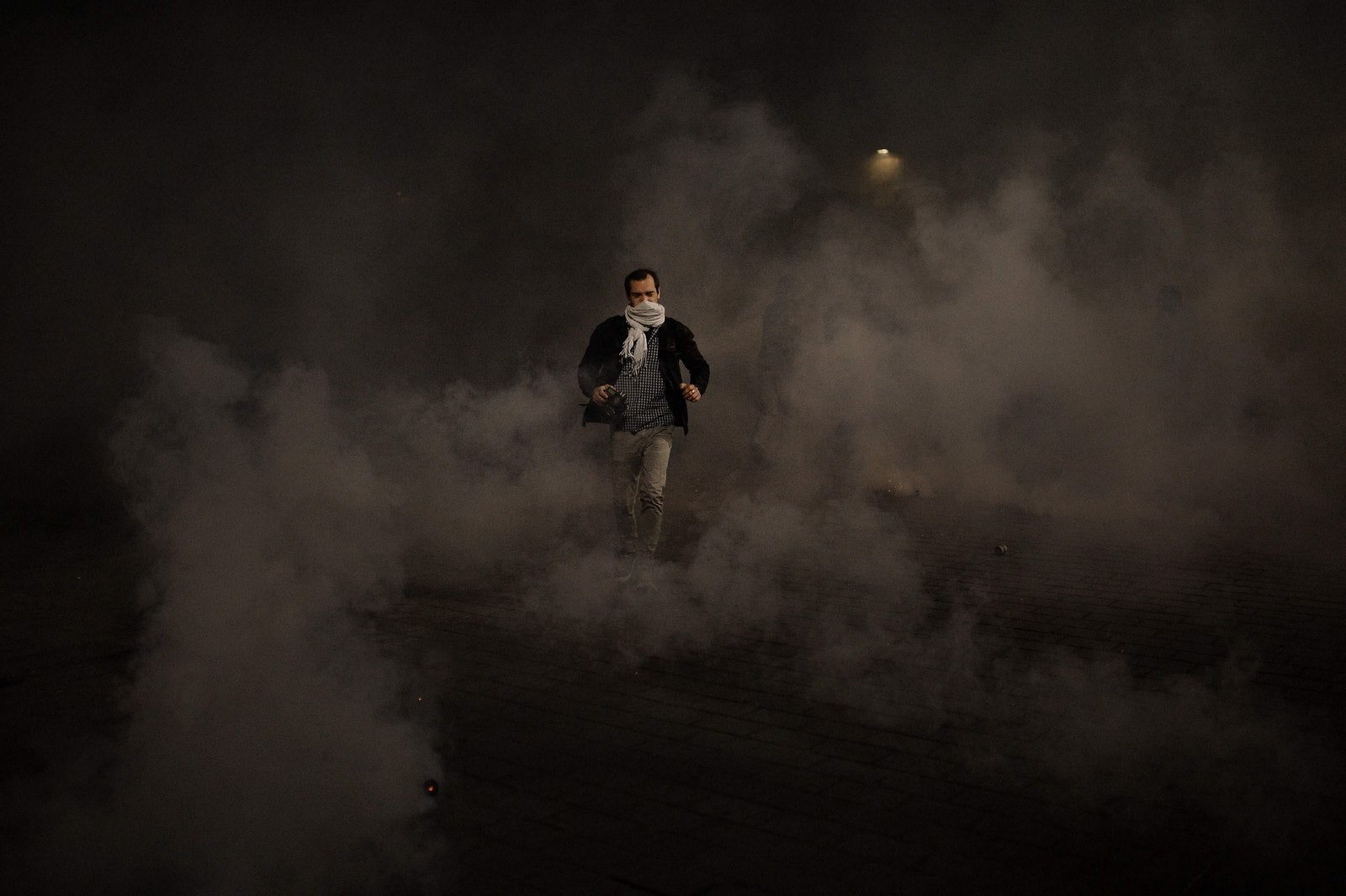 Manifestantes huyen de los gases lacrimógenos y de la policía antidisturbios durante una manifestación en contra del uso del artículo 49,3 de la Constitución francesa, que permite al gobierno para eludir el Parlamento y fuerza a través de las reformas laborales