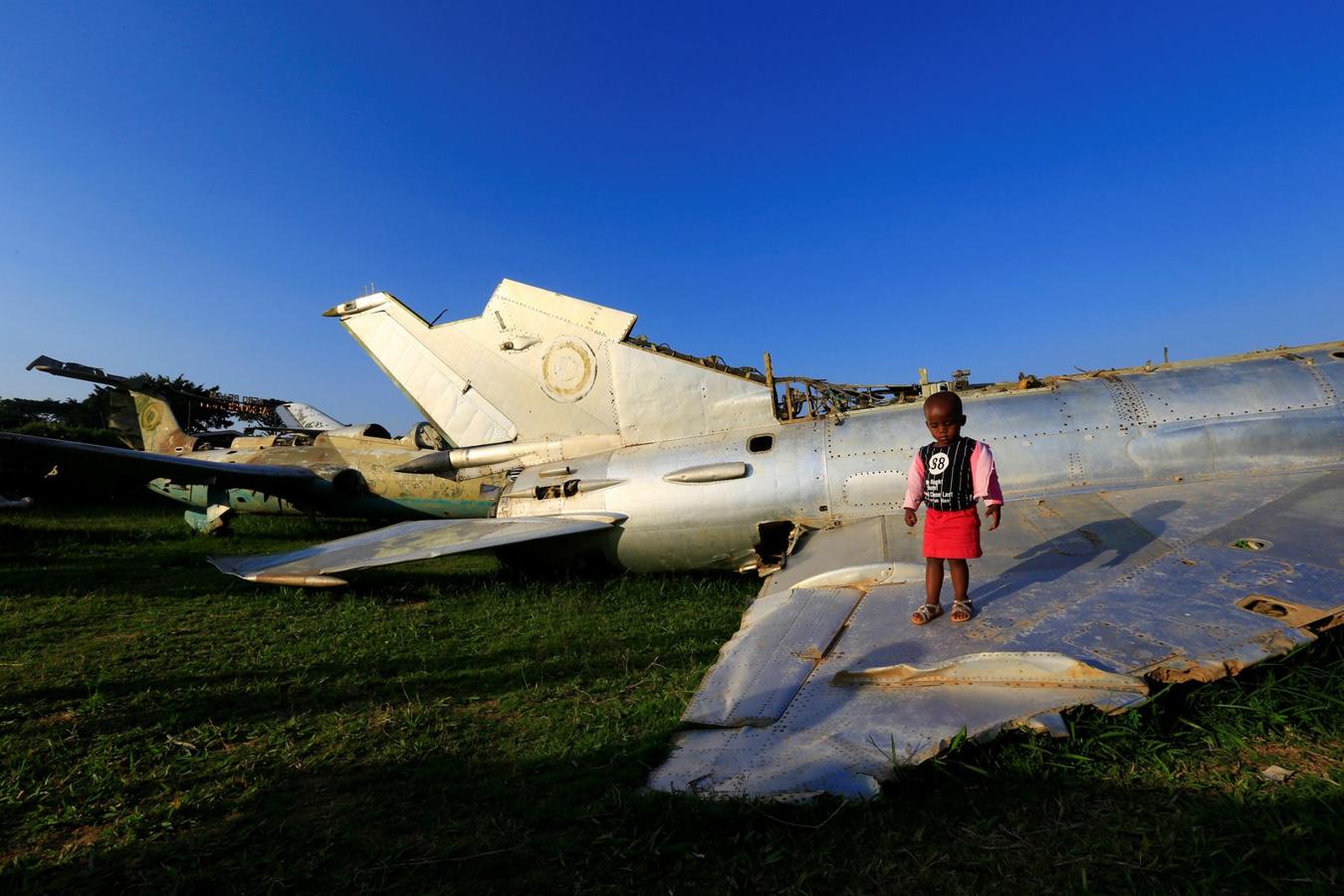 Un niño juega con aviones de guerra destruidos durante una operación israelí en el aeropuerto internacional de Entebbe en 1976