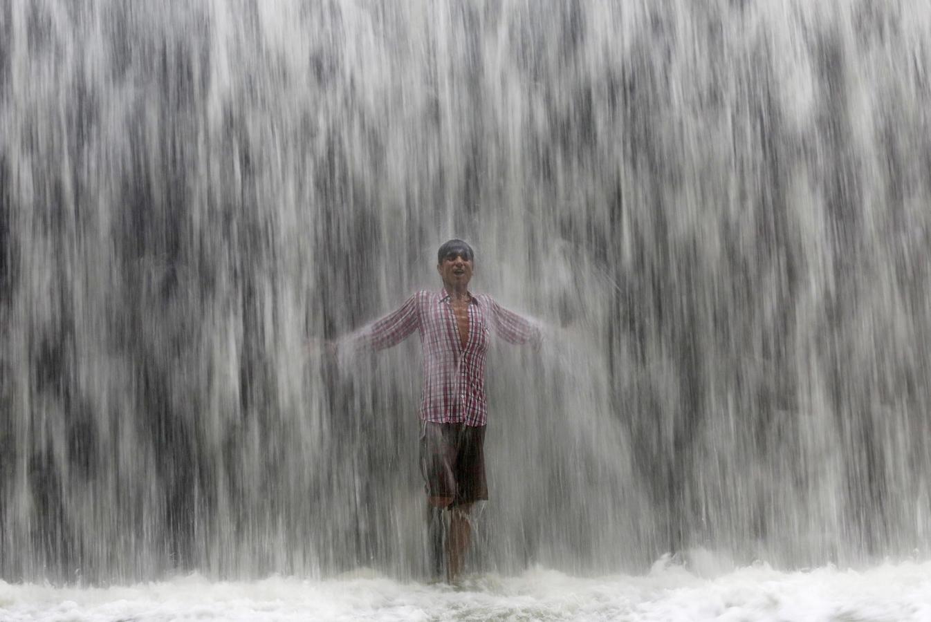 Un niño se encuentra bajo una presa a lo largo del lago Powai después de fuertes lluvias en Mumbai, India