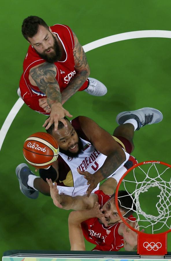 Gregory Echenique de Venezuela intenta disparar mientras Miroslav Raduljica y Stefan Birčević de Serbia defienden.