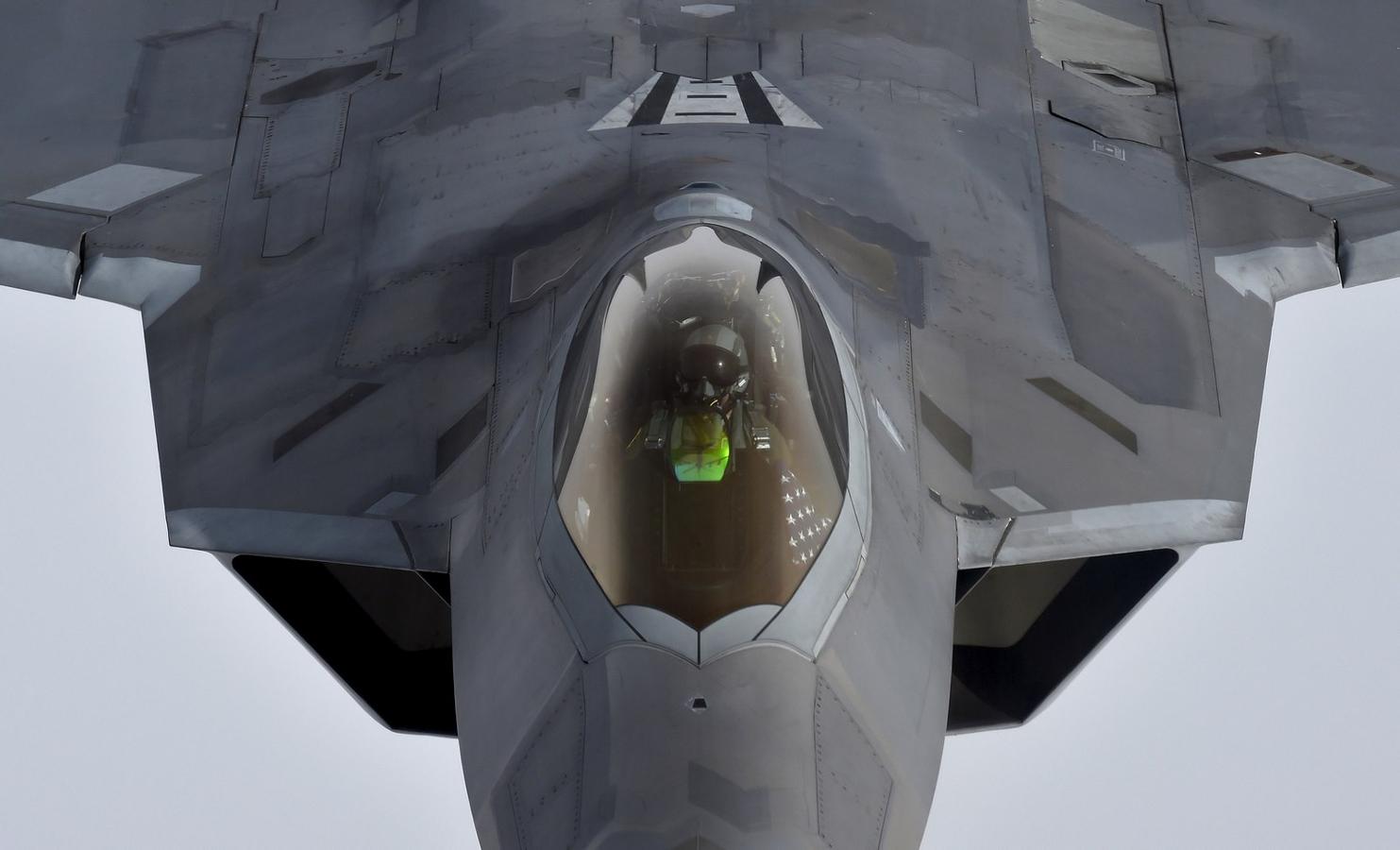 Un piloto mira hacia arriba desde un caza F-22 Raptor de Estados Unidos mientras se prepara para reabastecerse en pleno vuelo con un avión de reabastecimiento KC-135 durante un vuelo a Gran Bretaña desde la base aérea Mihail Kogalniceanu en Rumania