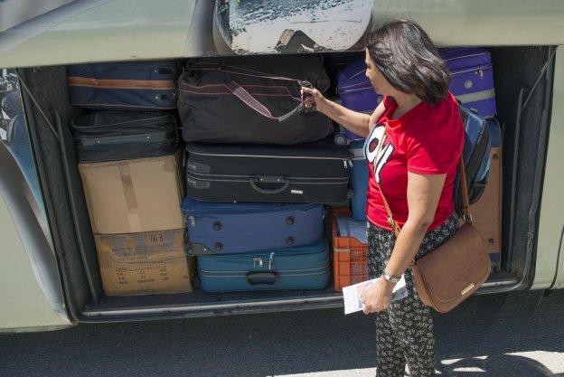 Jornalera coloca sus maletas en el autobús que la llevará a la vendimia francesa. 