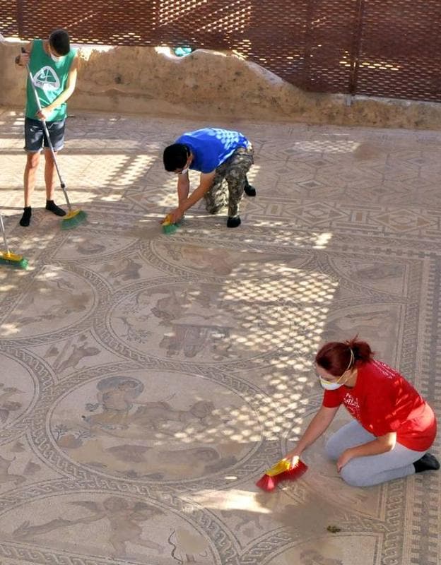 Voluntarios del Campo Internacional de Trabajo limpiando el Mosaico de los Amores. 