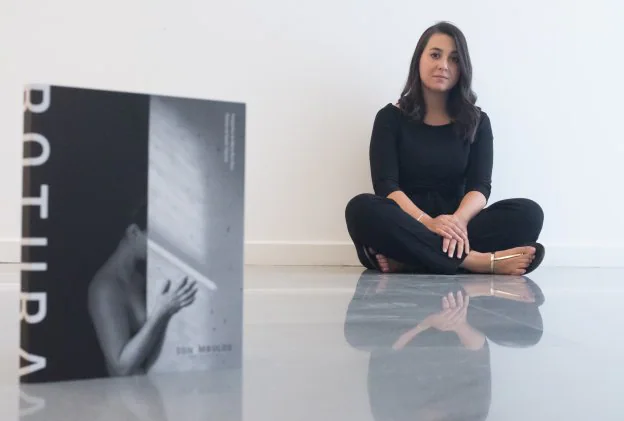 La fotógrafa Marta Ruiz posa junto a la portada del libro, 'Rotura', que edita Sonámbulos.