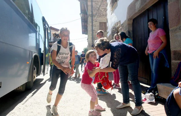 Las madres reciben en la parada del autobús a sus hijos, que no tardan en desperdigarse por el pueblo. 