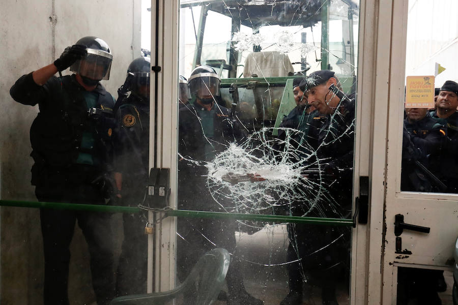 Agentes de la Guardia Civil fuerzan la puerta de un colegio electoral para acceder a su interior.