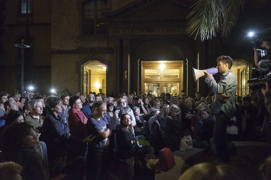 Un manifestantes arenga a un grupo de personas concentradas a través de un megáfono.