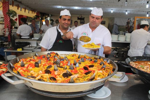 Juan Moreno, del barrio de La Magdalena, y Francisco J. Cruz, de Torredelcampo, con su 'macropaella'.