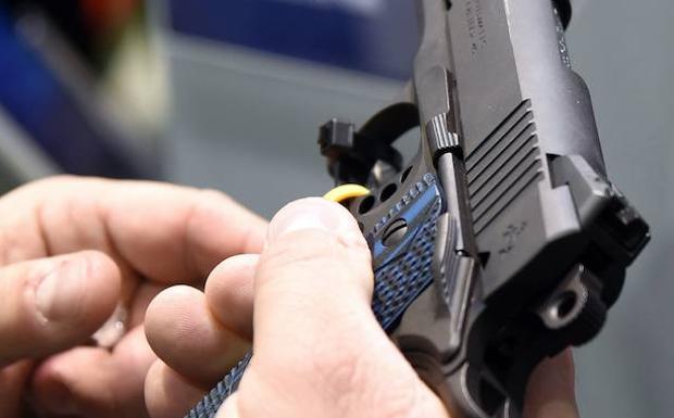 Una persona inspecciona una pistola Colt en la feria de Tiro y Caza de la Fundación Nacional de Deportes de Tiro, en Las Vegas. 