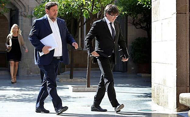 Puigdemont (d) y Junqueras caminan. 