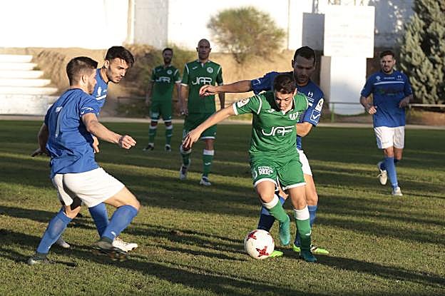 Un jugador del Atlético Mancha Real trata de zafarse de varios rivales del Maracena.