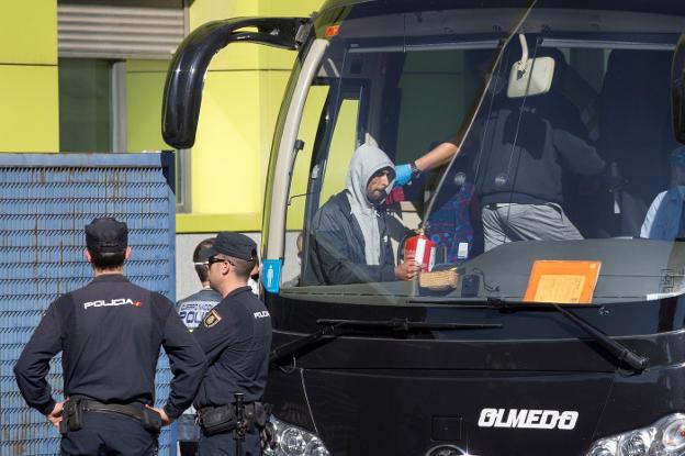 Varios inmigrantes llegados en patera el pasado fin de semana son conducidos por la Policía Nacional al autobús que los trasladó a la cárcel sin estrenar de Archidona.