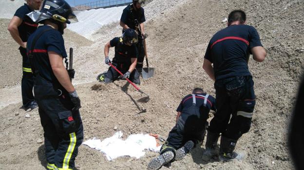 Bomberos se afanan por extraer el cuerpo del joven que fue sepultado por una montaña de yeso en el puerto de la capital.