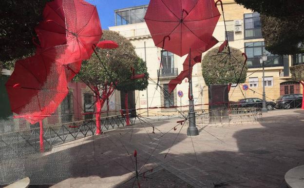Así ha quedado la instalación artística después de que unos vándalos destrozaran y prendieran fuego a globos y paraguas rojos en la plaza de Campoamor, en el corazón histórico de Almería. 