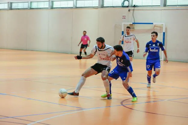 Un jugador del Sima protege la pelota ante el futbolista del Ceutí. 