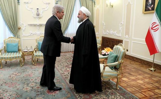 El presidente iraní, Hasan Rohaní (d), da la bienvenida a Dastis. 