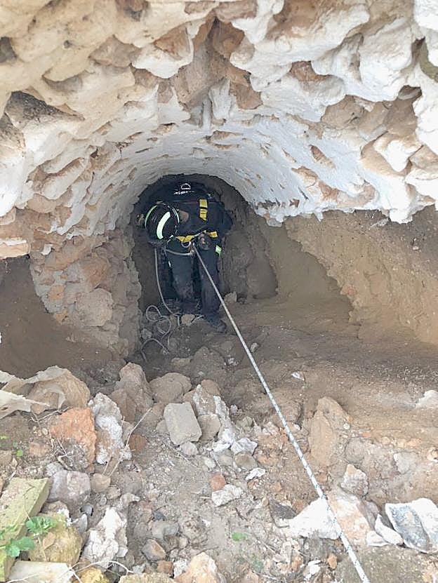Un bombero del Poniente se desliza al interior de un pozo en Las Negras. 