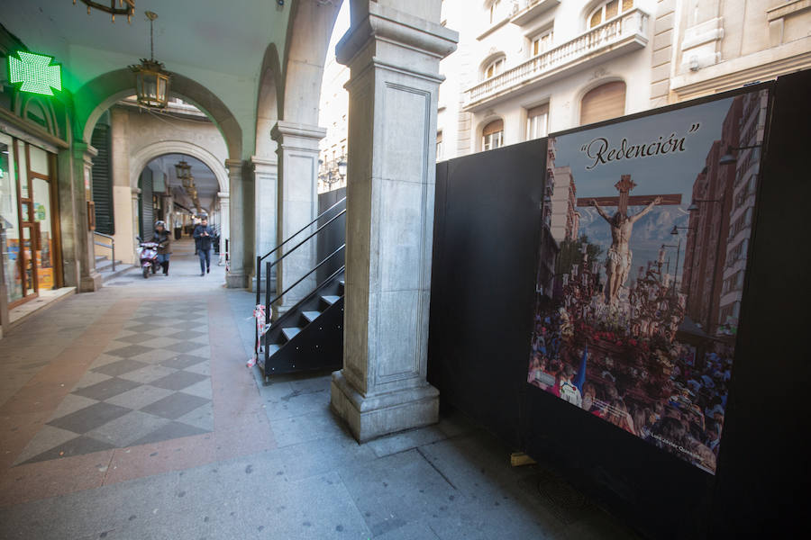 El Ayuntamiento inaugura una muestra de carteles con las fotos de Semana Santa de 2017 para embellecer la céntrica calle 'tapando' la parte trasera de las gradas de la carrera oficial.