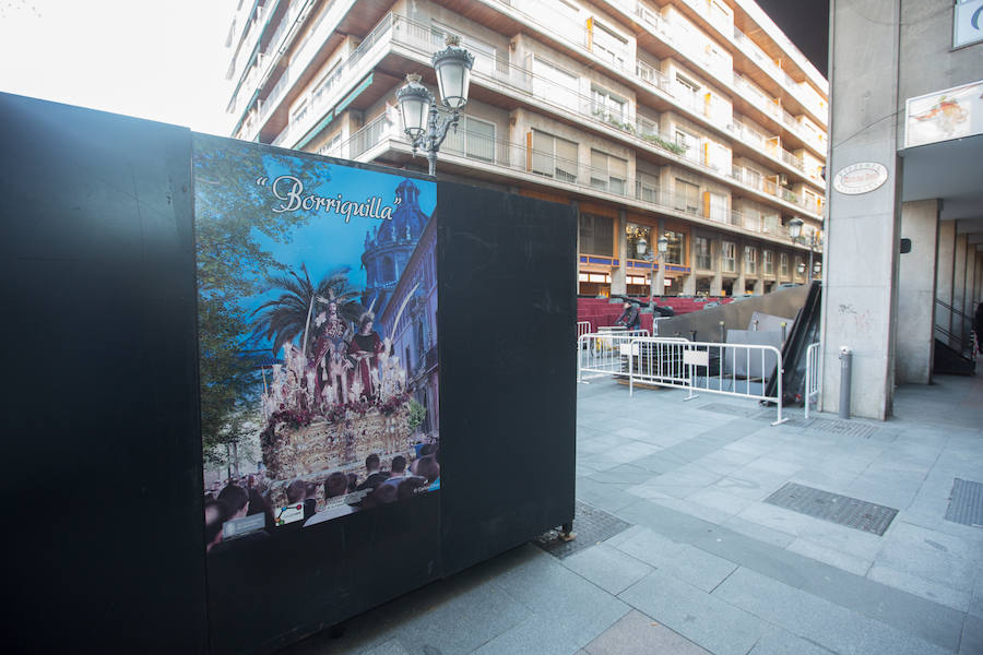 El Ayuntamiento inaugura una muestra de carteles con las fotos de Semana Santa de 2017 para embellecer la céntrica calle 'tapando' la parte trasera de las gradas de la carrera oficial.