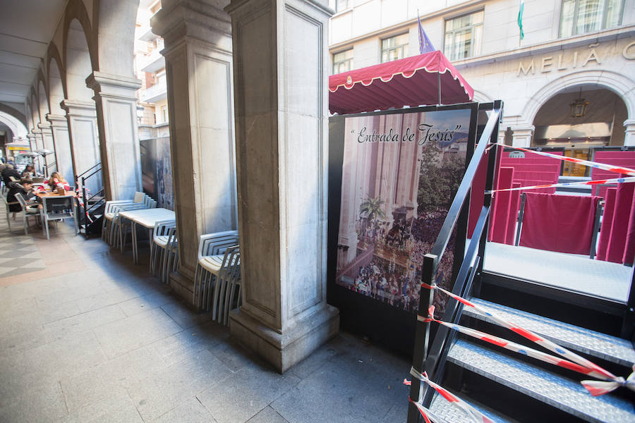 El Ayuntamiento inaugura una muestra de carteles con las fotos de Semana Santa de 2017 para embellecer la céntrica calle 'tapando' la parte trasera de las gradas de la carrera oficial.