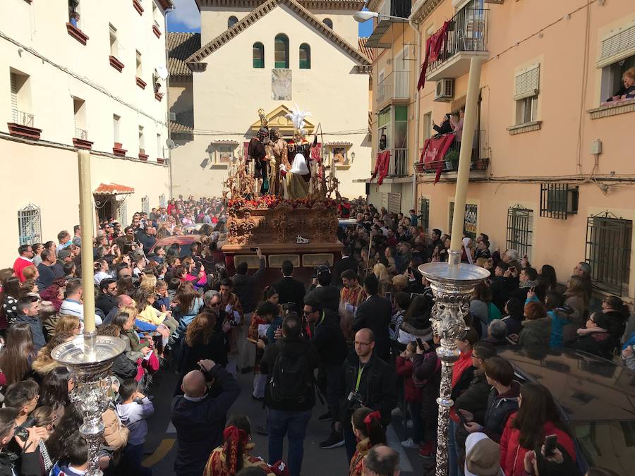 Las costaleras llevan al Cristo del Trabajo en un día radiante por las calles del Zaidín 