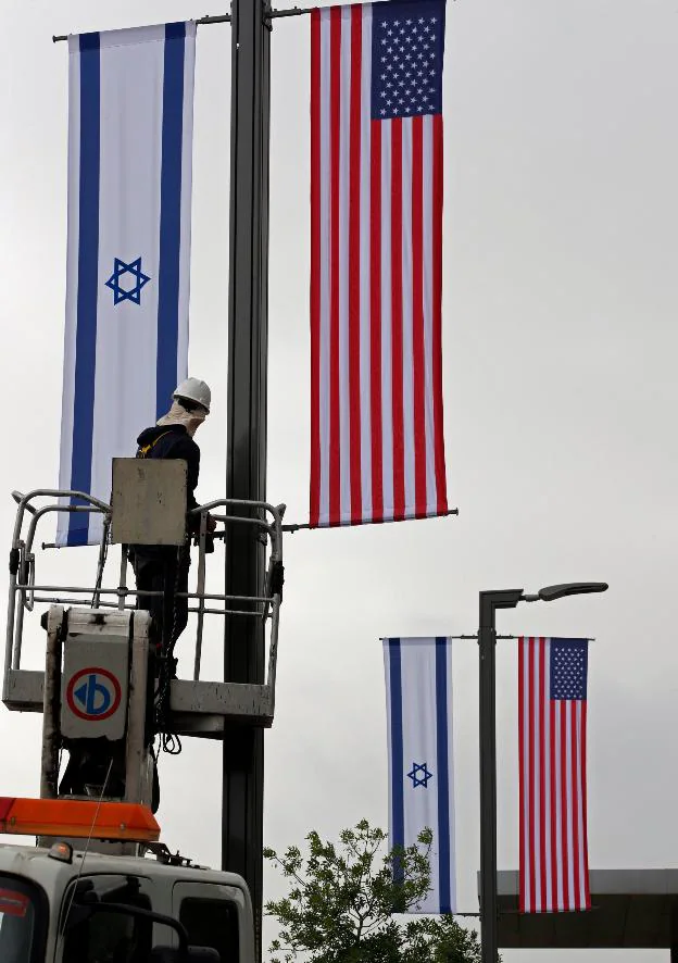 Un trabajador coloca banderas de Israel y EE UU en Jerusalén. :: afp