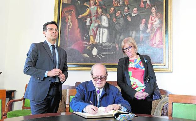 Pere Gimferrer firma en el libro de honor de Granada junto acompañado por el alcalde Francisco Cuenca y la edil María de Leyva.