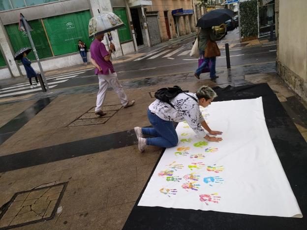 Una joven deja sus huellas en el lienzo contra la 'lgtbfobia'. 