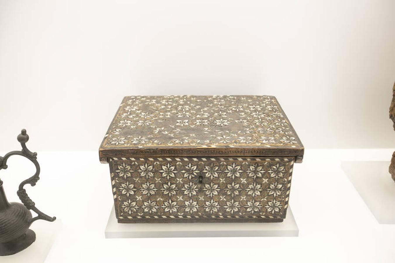 Arqueta de taracera. Arqueta rectángular con tapa plana encajada en la parte superior que sobresale ligeramente sobre las paredes de la misma en los tres frentes principales, cogiéndose en el posterior a la caja por dos bisagras largas. Altura = 15,50 cm; Longitud = 29,50 cm; Anchura = 24,50 cm. Granada, 1400 d.c - 1.500 d.c.