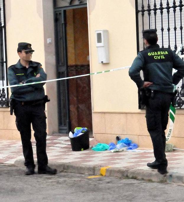 Dos agentes ante la vivienda donde ocurrieron los hechos.