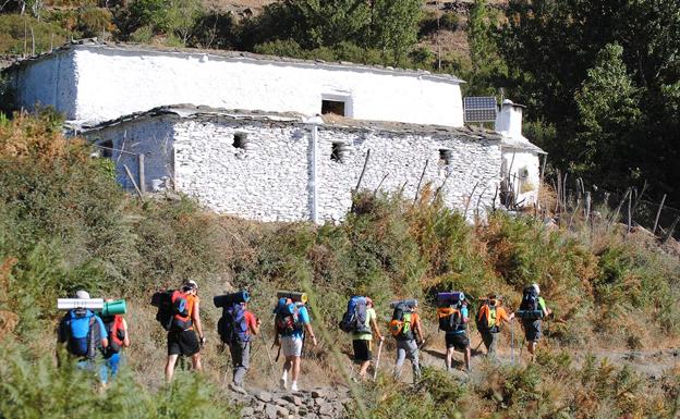 Senderistas caminan por los senderos de la Alpujarra camino de las altas cumbres