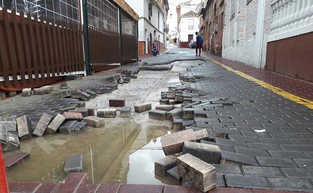 En la calle Cruces de La Zubia, la fuerza del agua ha levantado el adoquinado