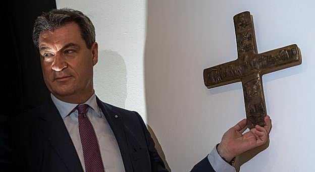 Markus Söder recoloca un crucifijo en su oficina el día en que firmó la orden que hace obligatoria su presencia pública. :: peter KneffelAFPXxxx. :: xx