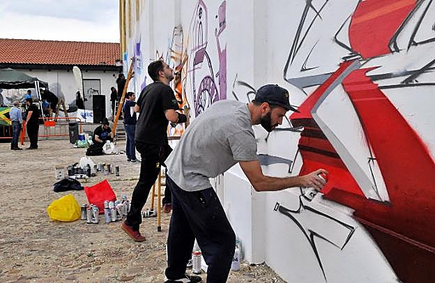 Jóvenes pintando murales en el Silo durante la celebración de la jornada de Cultura Urbana.
