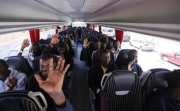 Los chicos que han dormido en la Nave de los Arcos dicen adiós en el autobús. 