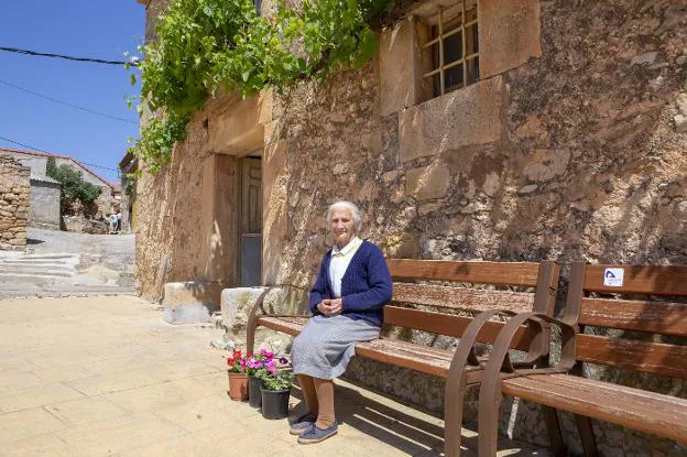 Primitiva, de 82 años, la hermana del cura, ya jubilado, de la Riba de Escalote, sentada en un banco de la casa parroquial.