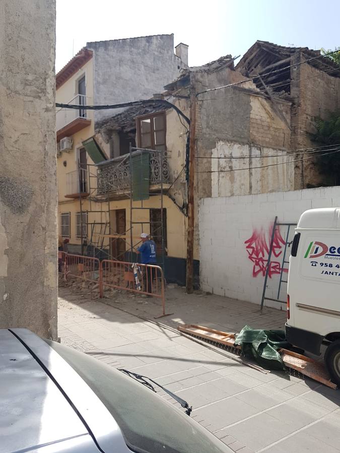 Unos trabajadores tienen que saltar del andamio en el que estaban retirando las tejas de un edificio al empezar a caerse la fachada