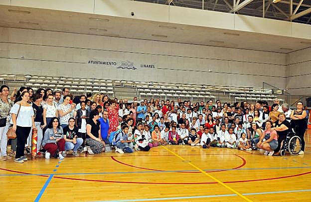Los niños que han venido este año, sus familias de acogida, miembros de la asociación y autoridades, en el pabellón Andalucía.