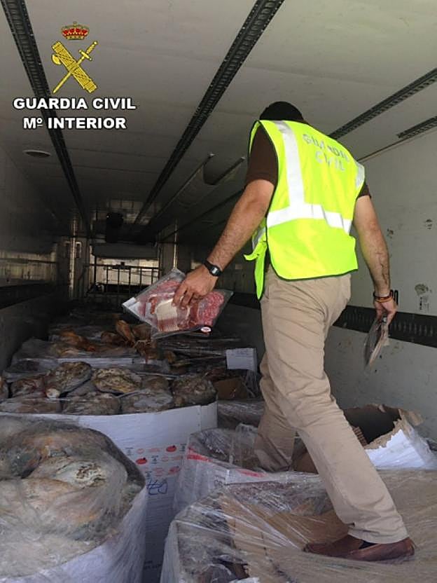 Un agente de la Guardia Civil examina la mercancía intervenida. :: G. C. 