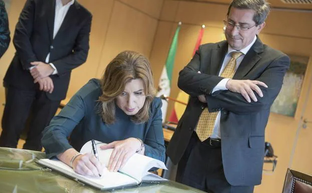 Susana Díaz firma en el libro de Diputación, con el presidente y secretario del PSOE de Granada, José Entrena, al fondo.