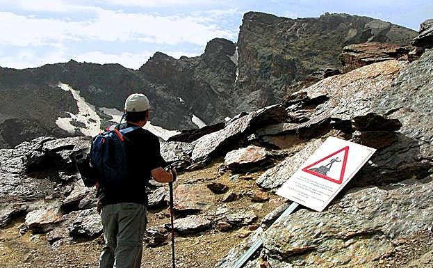 En las proximidades del Veredón del Veleta, un cartel avisa de que no se puede subir a las rocas para hacer fotos, altera el ecosistema y es peligroso.