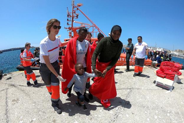 Un bebé y su madre reciben ayuda de los voluntarios de Cruz Roja, en el puerto de Tarifa (Cádiz) . 