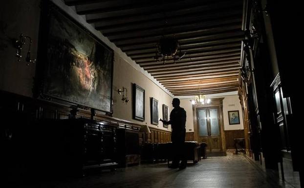 El vigilante ilumina 'La rendición de Granada' en la galería de los alcaldes.