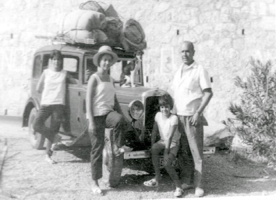 Celia sentada en el parachoques del coche de su padre . 