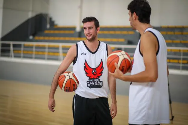 Joan Pardina sostiene el balón con el brazo derecho, junto a Sergio Olmos, de espaldas. 