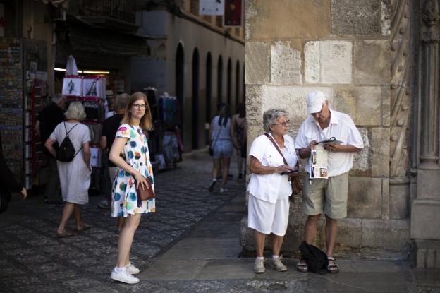 Turistas de visita por la capital granadina, en la calle Oficios, cerca de la Capilla Real.