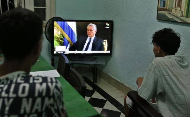 Dos jóvenes ven la entrevista al presidente cubano desde La Habana.
