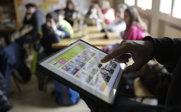 Un alumno usa una tableta durante una clase. 