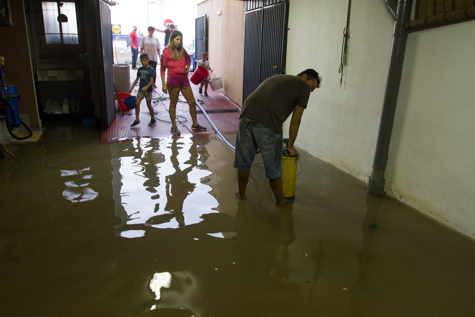 Los vecinos de algunas zonas del municipio se han visto obligados a achicar el agua que ha entrado en sus viviendas