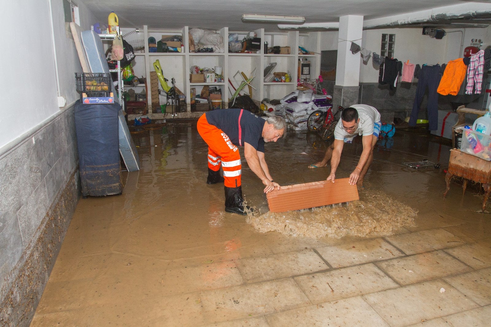 Los vecinos de algunas zonas del municipio se han visto obligados a achicar el agua que ha entrado en sus viviendas